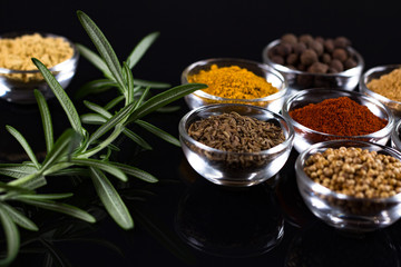 bowls of various dip sauces on black background, top view