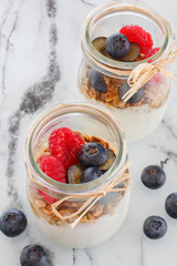 Glass glass with yogurt, raspberry, blueberry, cereals. Serving of breakfast