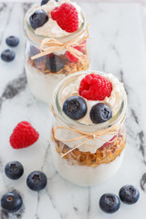 Breakfast healthy food in a portioned container with yoghurt, berries, cereals