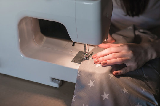 Women's hands behind her sewing.