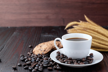 Coffee cup and coffee beans on wooden background
