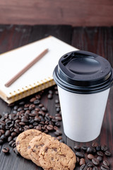 Coffee cup and coffee beans on wooden background