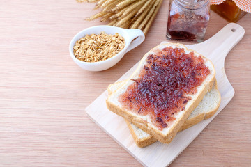 Bread with jam grape on wood background
