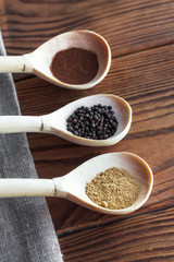 Various spices on wooden spoons