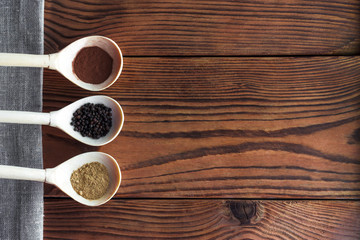 Various spices on wooden spoons