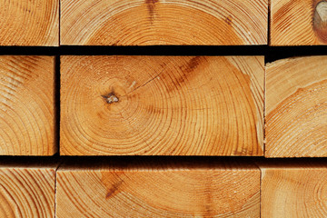 Holz-Hintergrund: Jahresringstruktur gestapelter Bauholzbalken aus Kiefernholz