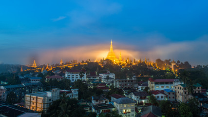 Fototapeta premium Shwedagon Paya pagoda in Gold Mist in the morning before sunrise .Myanmar famous sacred place and tourist attraction landmark.Yangon,