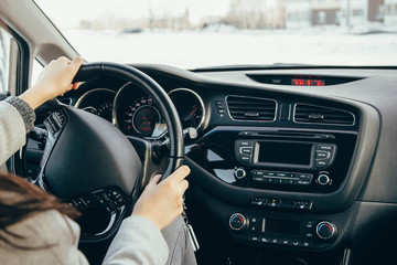 Female hand on the driving wheels. Driving a modern car steering wheel and hand close-up.