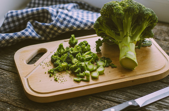 Fresh broccoli on wooden table, on a cutting board
