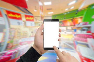 Man in supermaket holding modern phone in hands. Shopping online concept, free space for text. Empty white screen