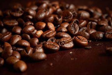 Close up of fresh Roasted coffee beans on brown background