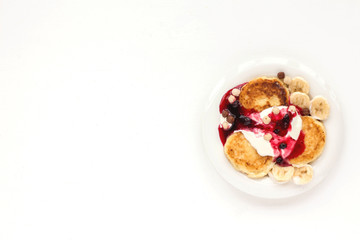 Fototapeta premium Dessert with yogurt, muesli, banana, pancake and berries on white background. Flat lay