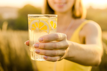 Diet. Healthy eating .Woman hand holding lemonade drink  on the background blurred nature outdoor. Fresh detox vegetable juice. Healthy lifestyle, vegetarian food. Nutrition Concept. - obrazy, fototapety, plakaty