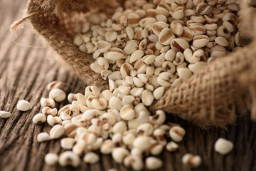 organic millet pour from sack on wooden rustic table