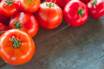 Ripe fresh red tomatoes on wooden table background.