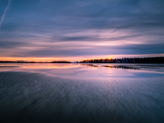 Obraz premium Sunset over partly frozen lake in Sweden