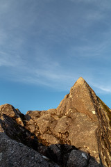 Sun hitting a cliff with blue sky as background