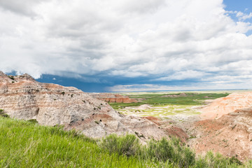 Dark blue storm cloud in Badlands National Park with prairie valley view