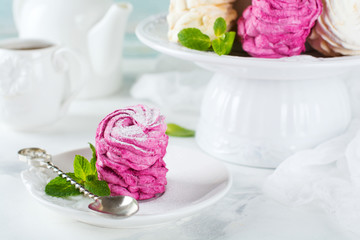 Homemade marshmallows on a light background. Russian currant and mango zephyr. Selective focus.