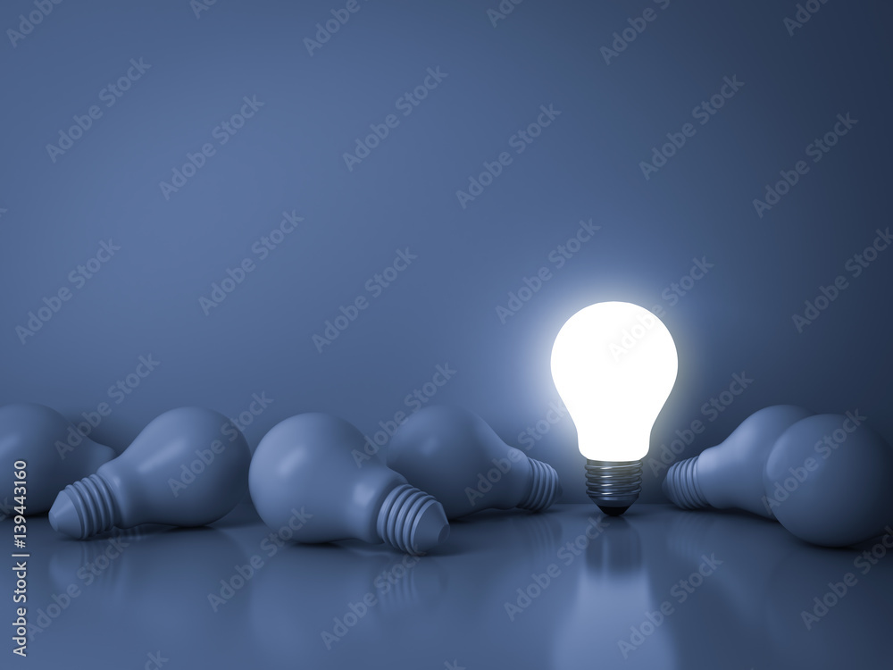 Leinwandbilder one glowing light bulb standing out from the unlit incandescent bulbs on blue background with reflec