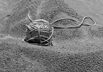 Black and white skein of twine on a sandy seashore