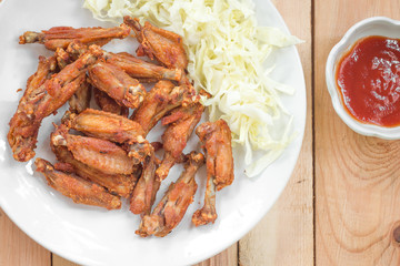 Chicken wings in plate with tomato sauce.