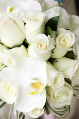 Obraz na płótnie Canvas beautiful white and yellow wedding bouquet of roses and orchids on dark background