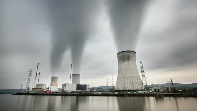 Long exposure time lapse sequence of a large nuclear power station on a dark gray day