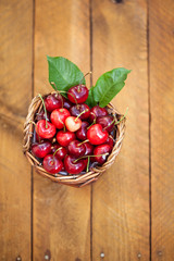 Freshly picked cherries in Cute Basket on a wooden Table