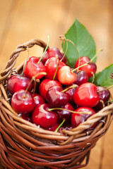 Freshly picked cherries in Cute Basket on a wooden Table