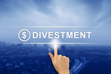 hand clicking divestment button on touch screen