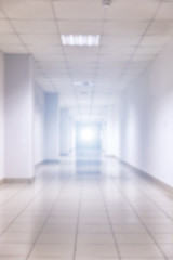 Abstract blur white empty interior room or blurred corridor with light at the end wall