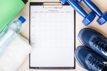 Personal workout plan with sneakers, water and dumbbells. Top view image