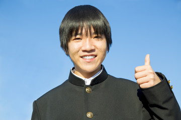 グッドサインする学ラン姿の男子高校生のアップ