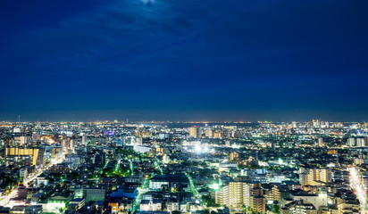 Business and culture concept for real estate and corporate construction - panoramic modern city skyline bird eye aerial night view under dramatic neon glow and beautiful dark blue sky in Tokyo, Japan