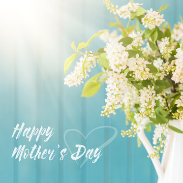 Beautiful white flowers in a vase, on blue wooden background, Mother's day concept