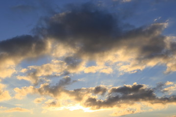 Naklejka na ściany i meble Clouds and sun beams on evening time