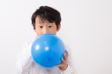 風船を膨らます少年