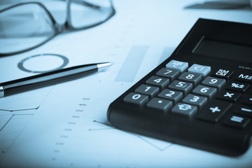 Business and finance concept.Calculator,chart,document,pen and graph on the table.