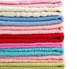 Stacked colorful towels on white background