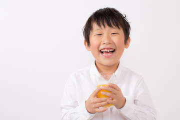 オレンジジュースを飲む子供
