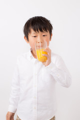 オレンジジュースを飲む子供