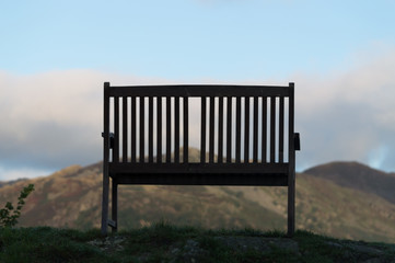 Fototapeta na wymiar Traveler's Rest Empty bench at top of hill looking out 