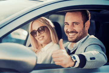 Young couple buying car at dealership center