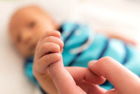 Neugeborenes Baby Säugling greift Hand der Mutter