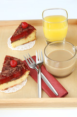 served romantic breakfast for two: morning cup of brewed coffee with milk, glass of orange juice and delicious cherry cheese cakes on coffee table