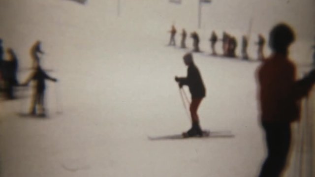 Skiers having fun (both expert and amateur). Super 8 mm film vintage shot.