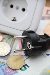 Steckdose mit Stecker und Geld im Hochformat