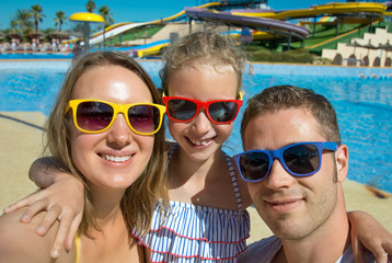 Happy family taking selfie on vacations in aqua park.