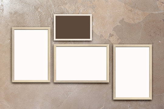 Template of blank posters in wooden frames on texturized brown stucco wall